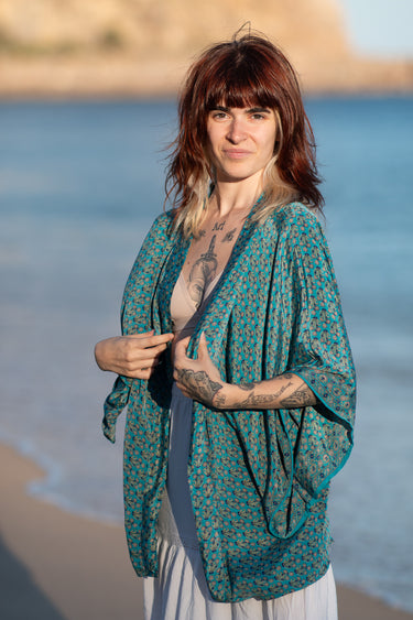 Quimono Aura curto seda sari reciclado turquesa mangas amplas abertura frontal praia Raja Pura - vista retrato lado